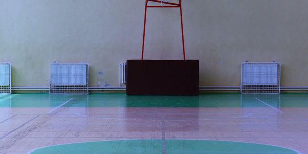 Minimalist fitness studio with large windows and wooden floor.